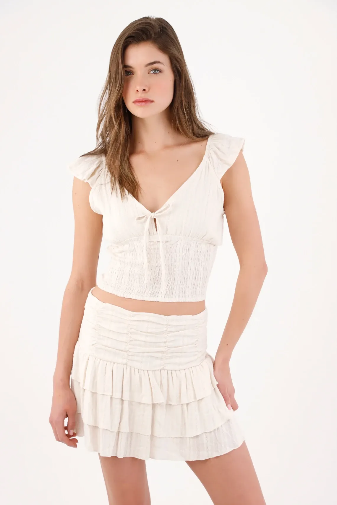 Blusa cropped entallada con lazo y nido de abeja en algodón crudo para mujer