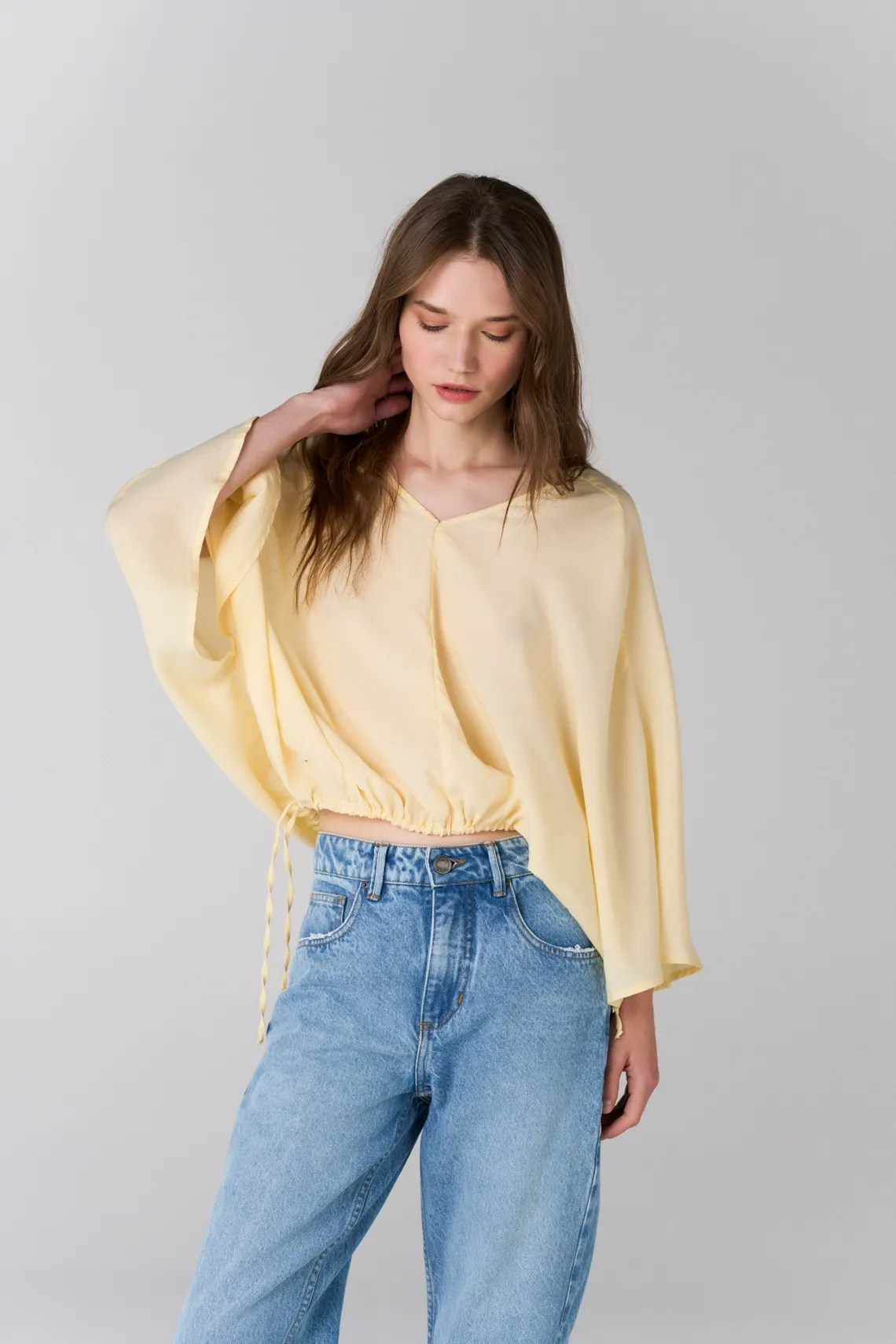 Camisa relajada con bajo fruncido y cordón en amarillo pastel para mujer